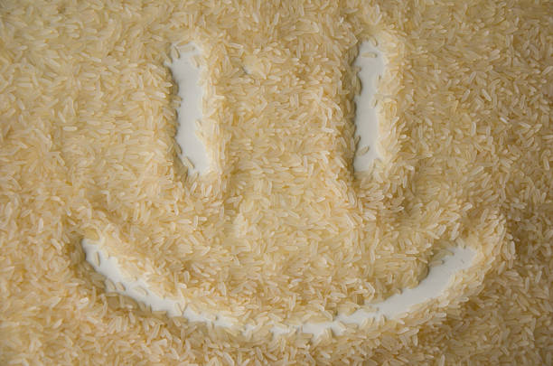 Closeup of raw rice grains arranged to form a smiley face, symbolizing happiness and positivity in food or cooking themes.