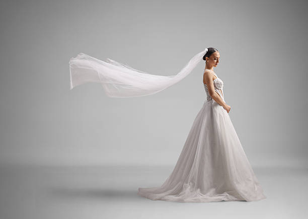 Full length profile shot of a bride in a sparkling ball gown with a flying veil