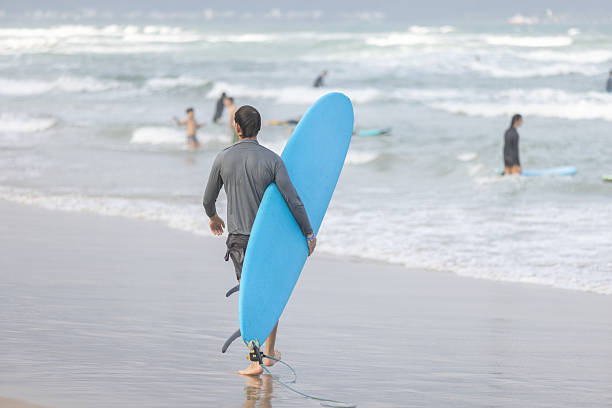 19 February 2026, Da Nang - Vietnam.Young surfer man is preparing to surf in South China Sea at My Khe Beach.