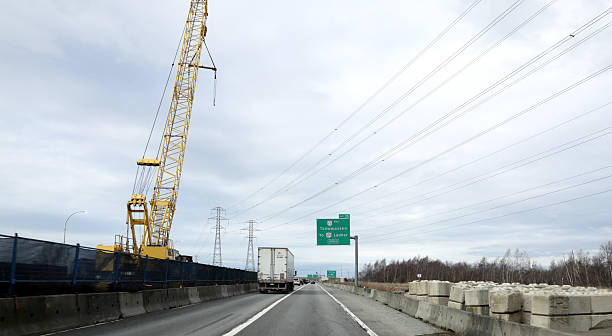 Delta, Canada - February 16, 2026: Looking west to traffic on Highway 99. Construction equipment behind barriers. Direction signs indicate Tsawwassen and Ladner at Exit 26. Overcast winter morning in Metro Vancouver.