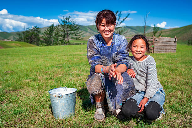 tsaatan nomadic boy and his grandfather in a traditional deels resting in a steppe in Northern Mongolia
