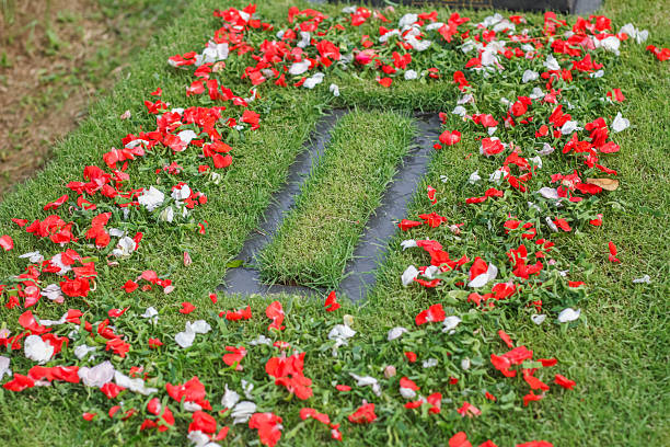 a thombstone  decorated with red and white flowers