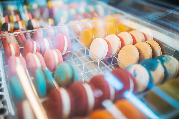 Vibrant macarons arranged in pastry shop display case.