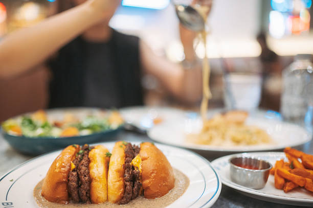 Close-up of gourmet premium truffle burger layered with melted cheese served alongside fries in modern cafe