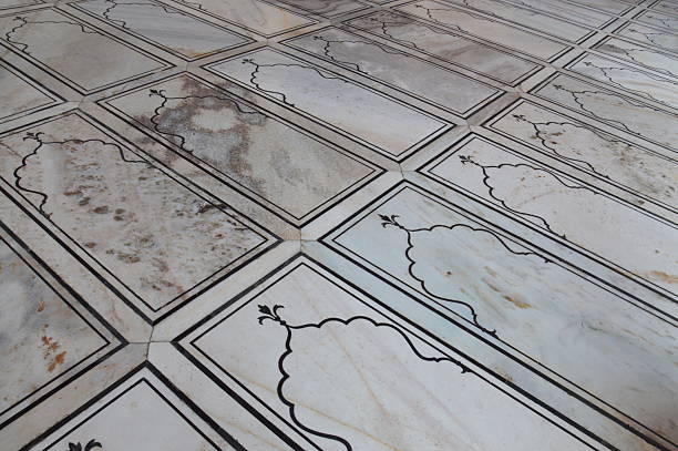 A low-angle perspective of ornate white marble flooring featuring black inlay borders and traditional Mughal-style arches at the Jama Masjid, Old Delhi, Delhi, India.