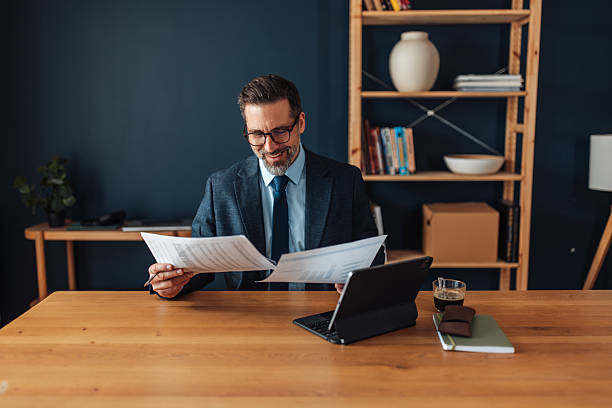 istock Happy professional reviewing reports in office 2262617059