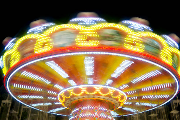 The carousel spins quickly while bright lights flash all around.