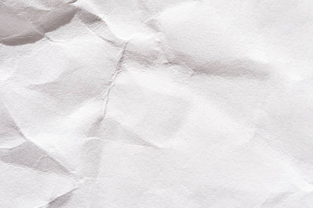 Crumpled white paper texture with shadows and creases for background design projects.