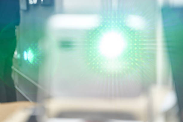 Blurred abstract green light beam with lens flare in a modern setting.