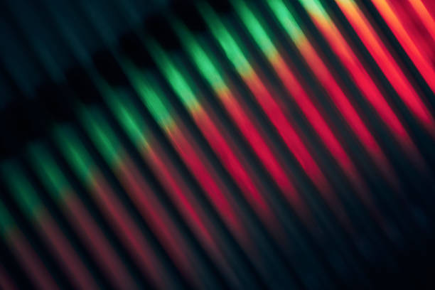 Blurred red and green diagonal light lines forming an abstract pattern on a dark background