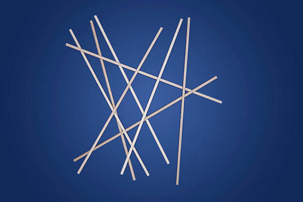 A group of wooden sticks is placed on a blue surface. The sticks are intersecting at various angles. This setup is used for a project at home.