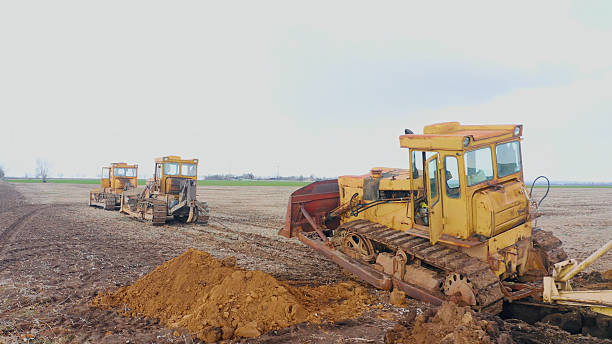 Old bulldozers digging a trench for land reclamation with agricultural plows