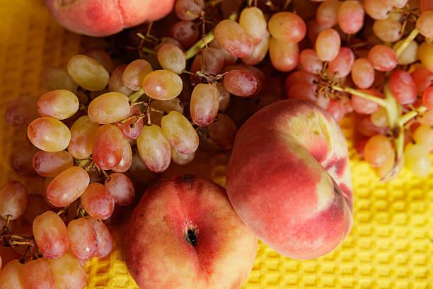 Grapes and peaches display vibrant colors on a cheerful yellow background, inviting a sense of joy and freshness.