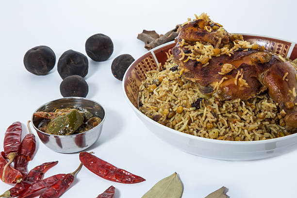 Delicious Chicken machboos biryani with spices and chutney on white background