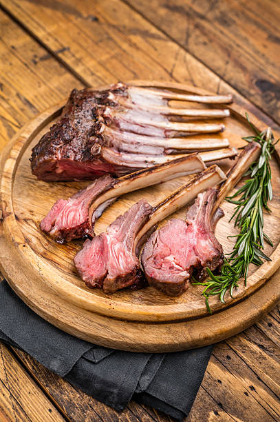 Grilled lamb chops, mutton meat cutlets steaks on wooden board. wooden background. top view