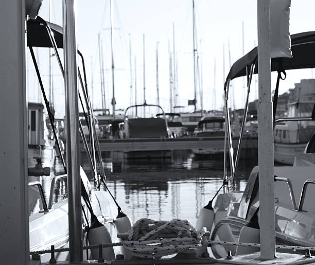 Modern white yacht, moored at a marina, seen from the back.