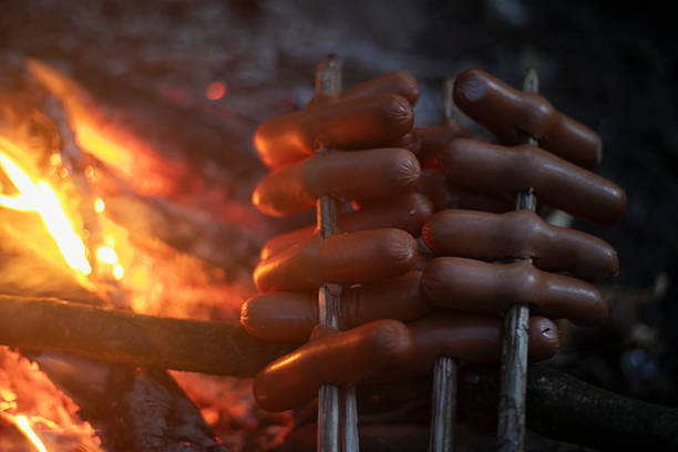 Sausages cooked on a campfire. Food on fire. Dinner in the wilderness. Delicious food.