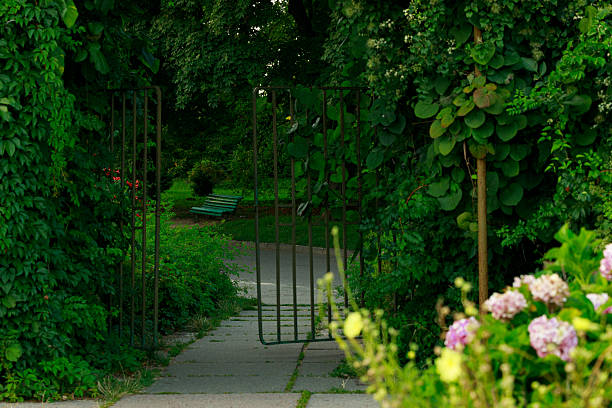 Small stone passage with dirt footpath in the gardens of Ambronay Abbey. This photo was taken at the Notre Dame d'Ambronay Abbey famous local monument in the French village of Ambronay, in the Ain department in the Auvergne-Rhone-Alpes region.