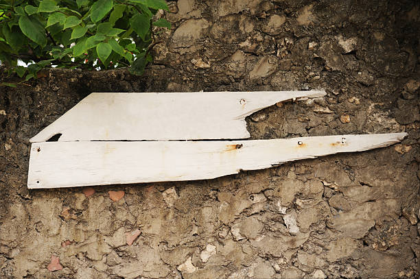 Two old white panels against a stone wall, rustic-style mockup for a sign or board.