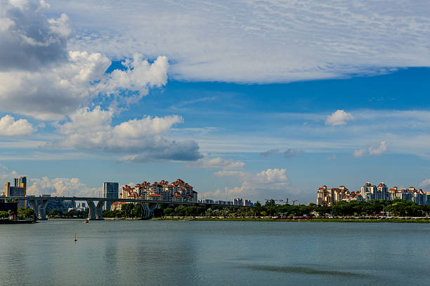 Peaceful city river with modern residential buildings rising in the background. Contemporary waterfront scene representing urban housing, real estate growth, and metropolitan lifestyle.