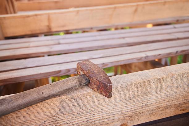 A hammer on the boards. Construction of a wooden frame house.