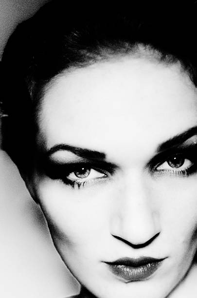 Close-up beauty portrait of a woman with classic studio lighting, strong eye makeup and cinematic expression, evoking golden age Hollywood elegance and modern fashion authority.