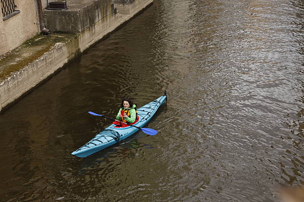 Female friendship group of women paddling, kayaking, standup paddleboarding, swimming, sunbathing   Summer refreshment by the water of a lake in nature. Relaxing and enjoying the lakeside, doing water sports.