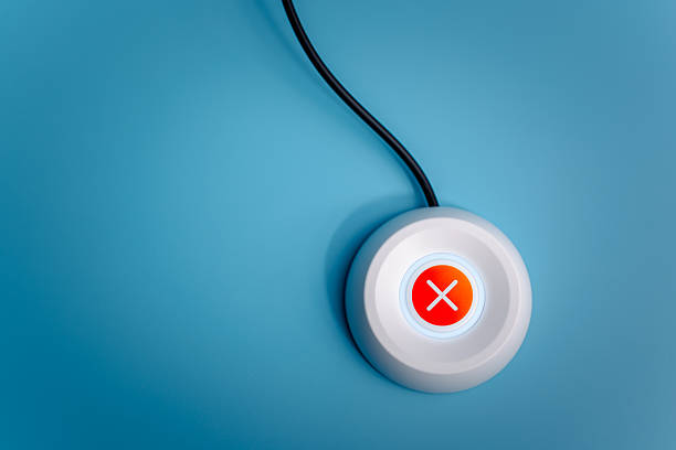 High-angle view of a white digital button featuring a red glowing cross mark icon on a blue background, symbolizing rejection, cancellation, error, stop action, and negative feedback response