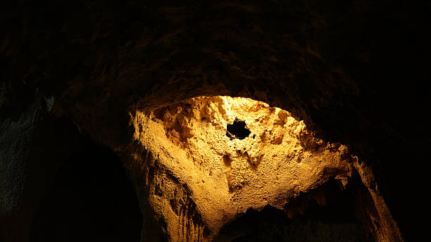 Cave ceiling illuminated by warm light, showcasing unique rock formations and textures, creating mystical atmosphere