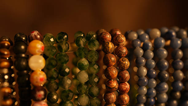 Colorful beads arranged in row, showcasing various materials and textures, creating vibrant display of jewelry making supplies