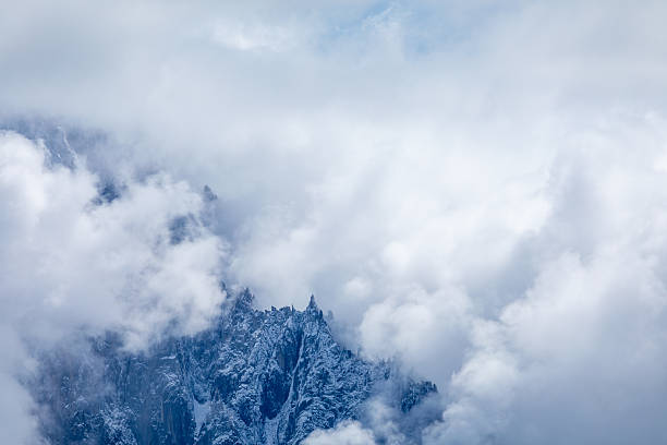 French Alpine mountain panoramic view with jagged peaks, glaciers and dramatic clouds in summertime