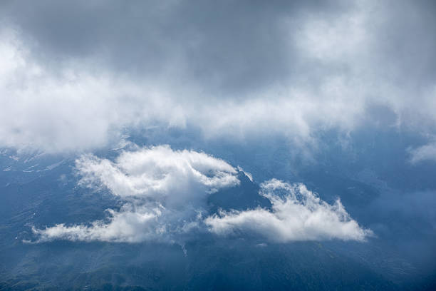 French Alpine mountain panoramic view with jagged peaks, glaciers and dramatic clouds in summertime