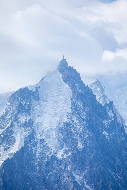 French Alpine mountain panoramic view with jagged peaks, glaciers and dramatic clouds in summertime