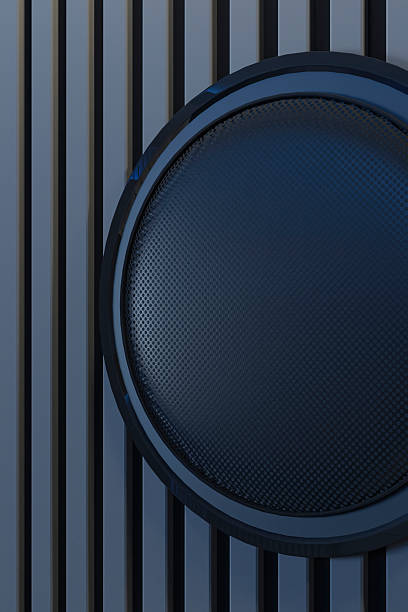 Modern wall speaker in home theater interior viewed from rear seating perspective. Foreground features a large, plush, tufted segmented sofa bed with pillows, completely bathed in deep blue ambient light. Dark polished tile flooring reflects the cool glow. The focal point is a massive blank black projection screen mounted on a wall featuring vertical acoustic slat paneling. A center channel speaker console sits directly below the screen. Intense blue LED strip lighting lines the ceiling coves and backlights the screen, creating a futuristic, monochromatic cool atmosphere. Symmetrical composition, architectural photography style, sleek minimalist design, cinematic lighting, high contrast.