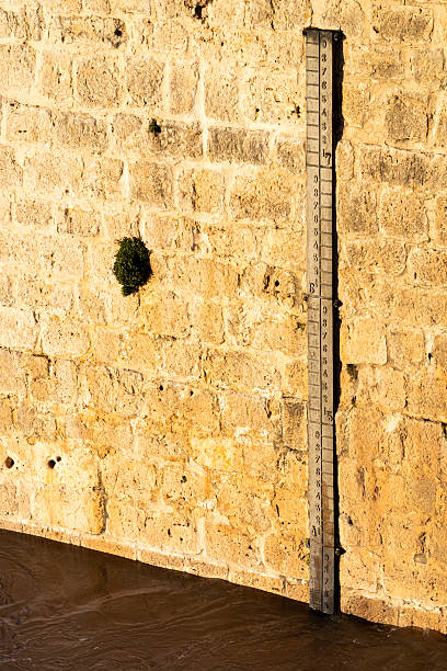 Water level gauge on an old stone wall along the douro river in tordesillas, showing the elevated water level during a flood, indicating environmental and climate impact