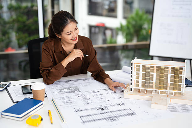 Smiling professional architects, engineers working on new construction project of building .