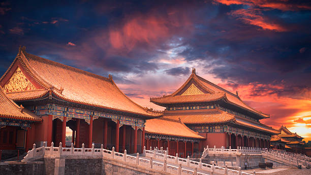 Panoramic view of the imperial palaces of the Forbidden City (Gugong) in Beijing. Traditional Chinese architecture of the Ming and Qing Dynasties, a UNESCO World Heritage site, captured under a vibrant sunset sky