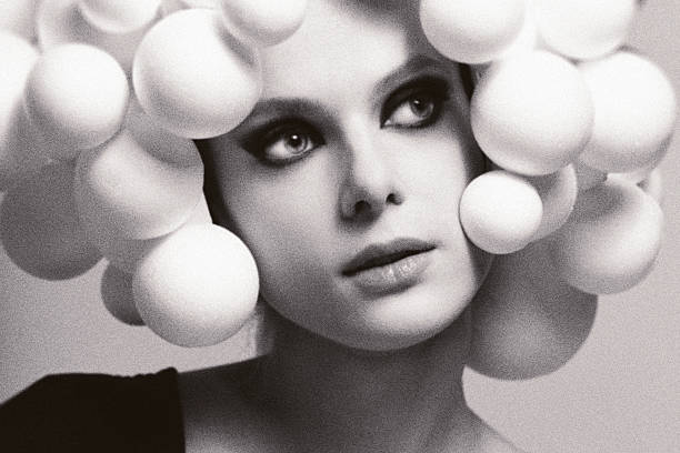 Woman styling unique fashion accessory, creating a conceptual portrait. Noise, grain and motion blur effect applied