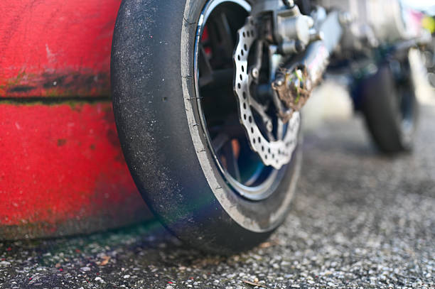 Rear wheel of a superbike with slick tire and brake disc on asphalt