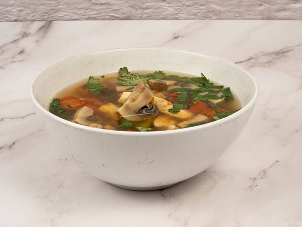 Thai Tom Yum Kha chicken soup on marble countertop
