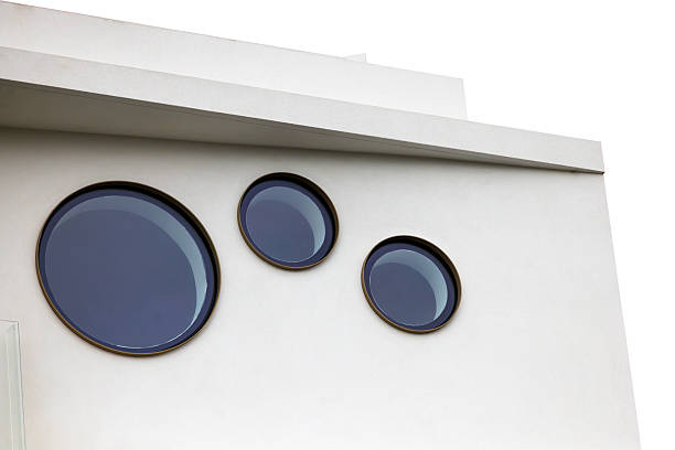 Closeup low angle view of modern, new apartment building with round windows, background with copy space, full frame horizontal composition