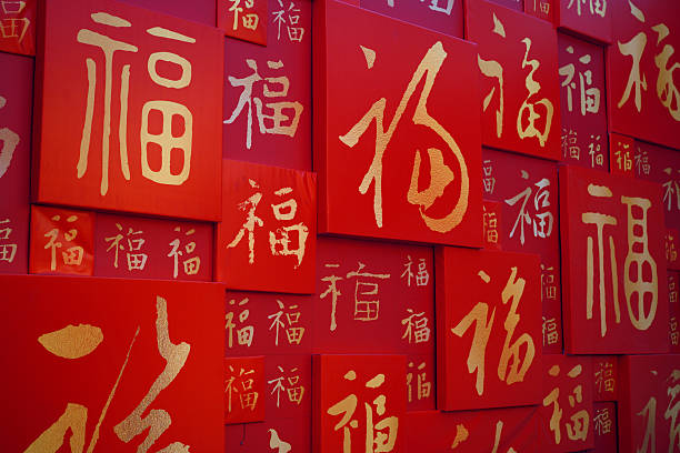 Red wall with multiple golden Chinese character 'Fu' symbols, representing traditional Chinese culture, festive celebrations, and good fortune.