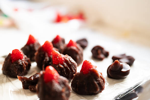 chocolate sweets in the form of a heart with fruits and nuts on a colored background. top view with space for text, holiday concept.