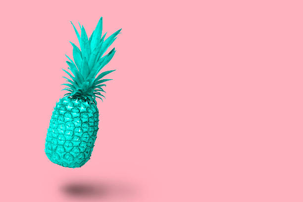 Design turquoise blue pineapple fruit floating on a pink background