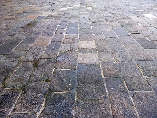 Wet street ancient paving stone floor, full frame view. Lugo city historic district, Galicia, Spain.