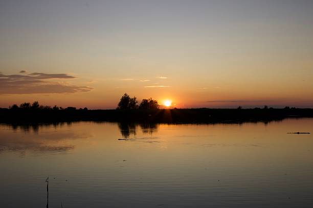 Bright sunset mirrored on still lake water