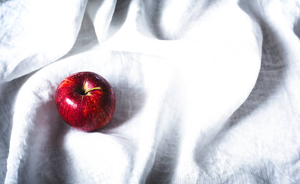 Single Red Apple on a White Wrinkled Linen Fabric