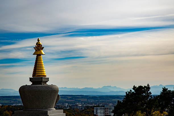 golden buddhistic Stupa in Austria on a hill with view to the sky and part of the city