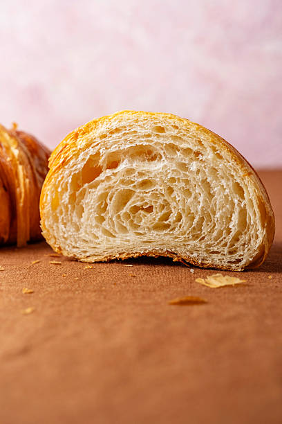 Croissant cut in a half. Homemade fresh golden croissant isolated on background