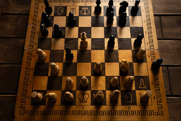 Chess board with wooden pieces ready for a match on a dark table surface
